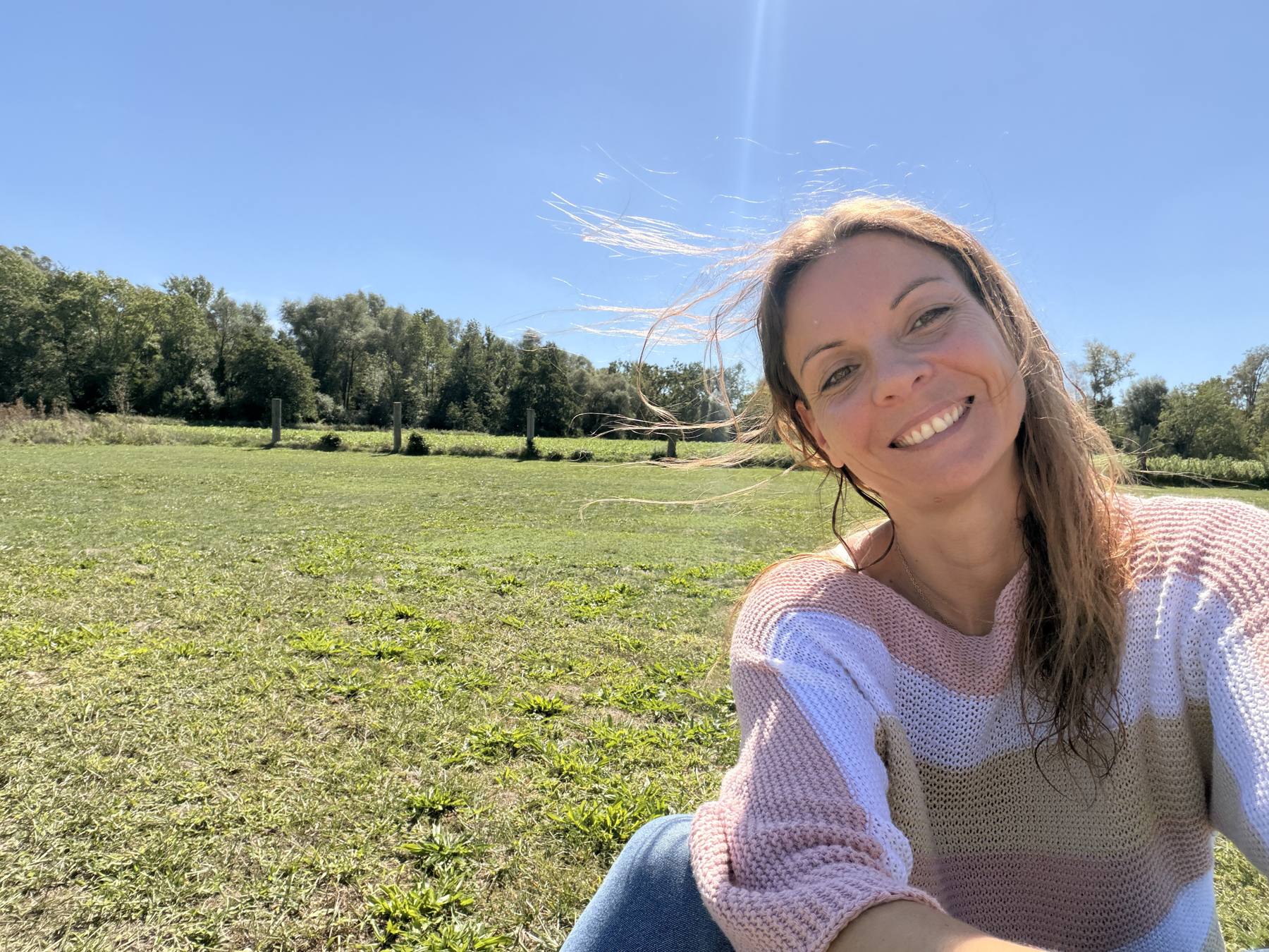 Melanie Gruber lachend auf dem Feld in warmer Septembersonne, Haare im Wind
